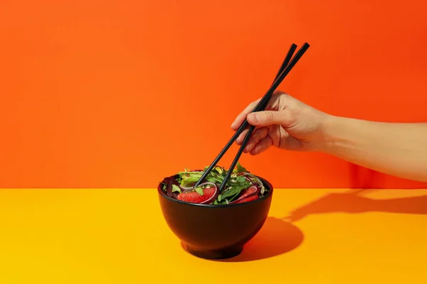 Weibliche Hand Mit Essstäbchen Und Salat Mit Roter Orange — Stockfoto