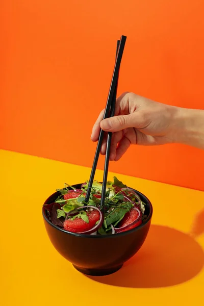 Mano Femenina Con Palillos Ensalada Con Naranja Roja —  Fotos de Stock