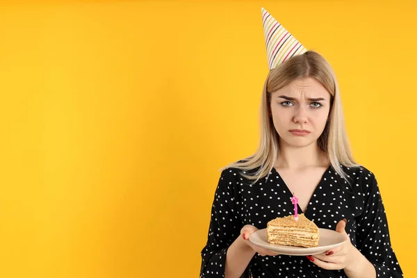 黄色の背景に誕生日 悲しい若い女性の概念 — ストック写真