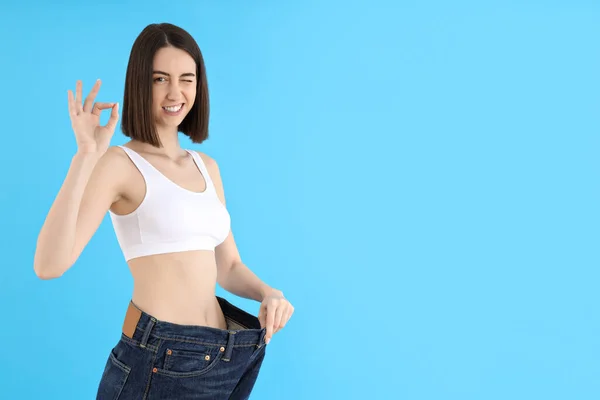 蓝色背景的年轻女子体重减轻概念 — 图库照片