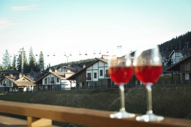 Kayak merkezindeki ahşap balkonda şarap kadehleri