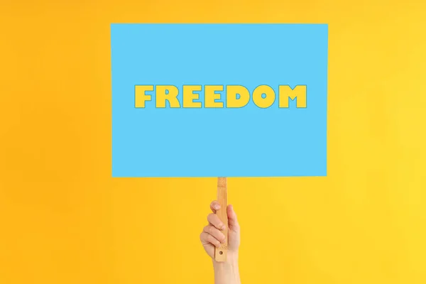 Female Hand Holds Protest Sign Text Freedom Yellow Background —  Fotos de Stock