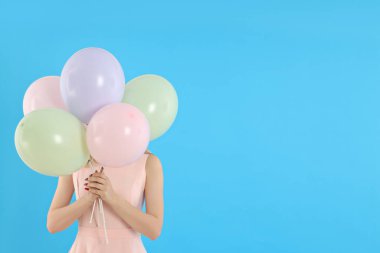 Concept of Happy Birthday, young woman with balloons on blue background