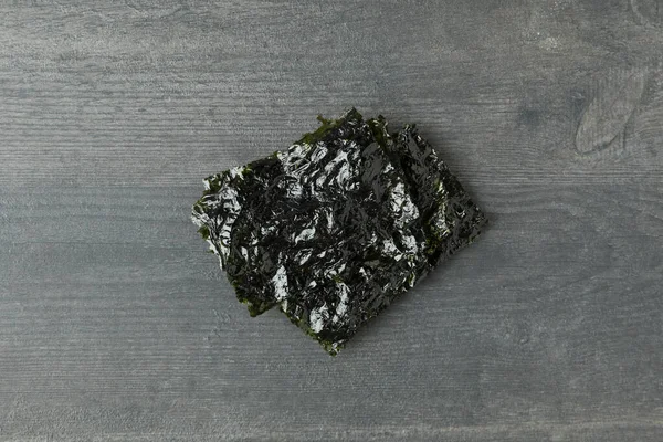 Japon yemeği kavramı, siyah ahşap arka planda deniz yosunu nori.