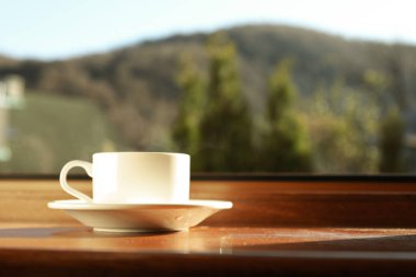 Bir fincan çay ahşap pencere eşiğinde duruyor.