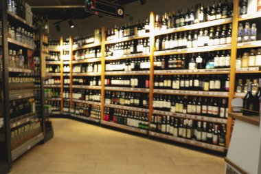 Alkol bölümünün farklı içkilerle çekilmiş bulanık fotoğrafı.