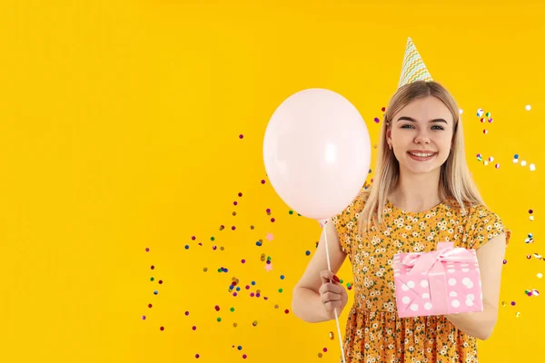 幸せな誕生日の概念とともに魅力的な女の子とともに黄色の背景 — ストック写真