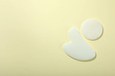 Yumuşak arka planda gua sha ile yüz bakımı kavramı