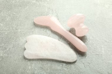 Gri dokulu arka planda gua sha ile kaldırma ve tonu tedavi kavramı