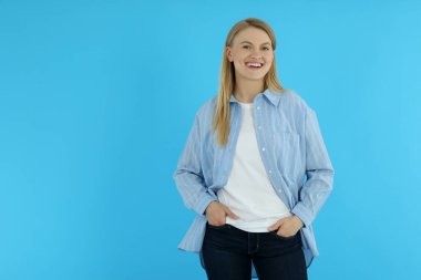 Mavi arka planda genç ve çekici bir kadın, mesaj için boşluk