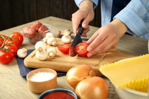 Lazanya pişirme kavramı, kadın sebze keser.