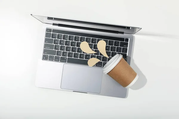 Concept of spilled drink, paper cup and decorative liquid on laptop