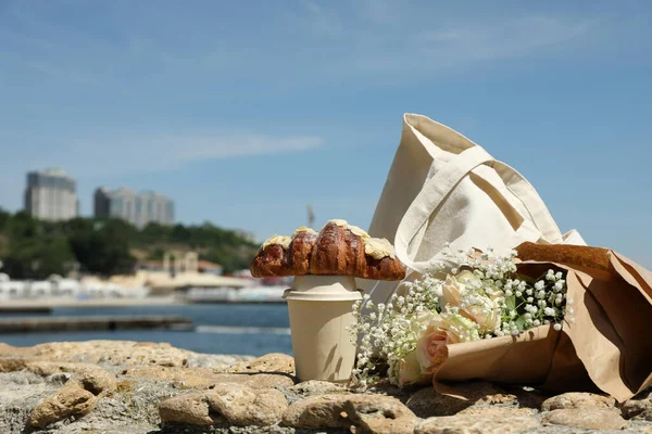 クロワッサンと紙コップで海の近くに素晴らしい朝食の概念 — ストック写真