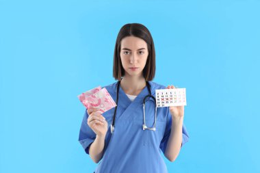 Meslek anlayışı, mavi arka planda genç bayan doktor.