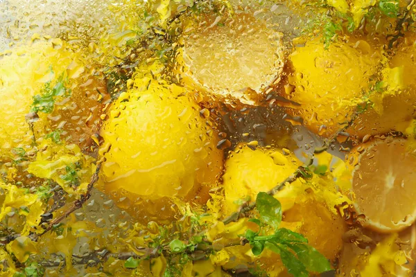 Wet glass background with lemons in the background