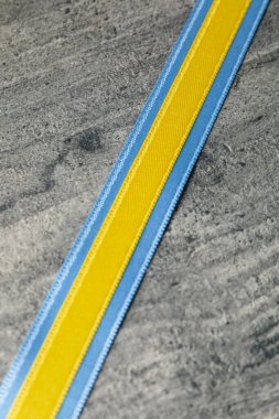 Ribbons in Ukrainian flag colors on gray wooden background