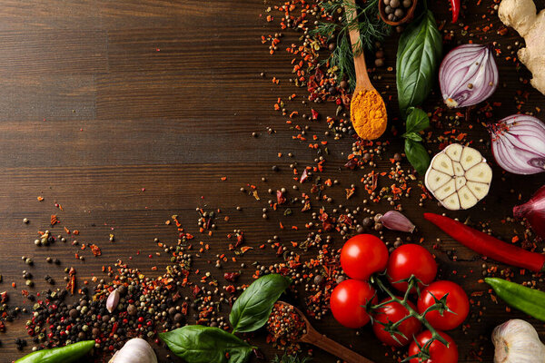 Different cooking ingredients and spices on wooden background