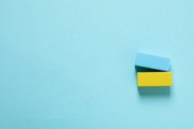 Blue and yellow erasers on blue background