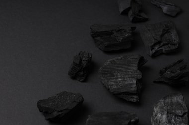 Flat lay with natural charcoal on black background