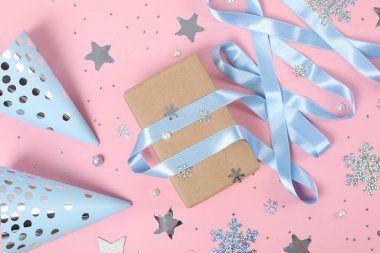 Concept of winter gift, gift box and accessories on pink background