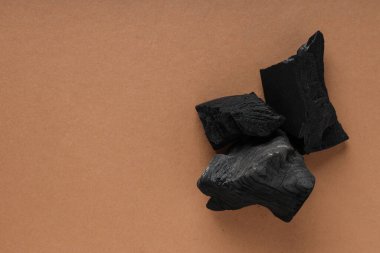 Natural hard wood charcoal on brown background