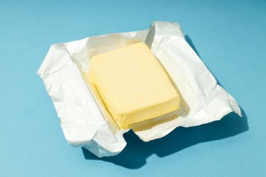 Open package with butter on blue background