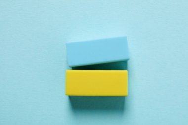 Blue and yellow erasers on blue background