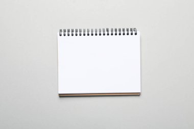 Blank notebook on light gray background, space for text