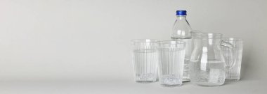 Jug, bottle and glasses of water, space for text
