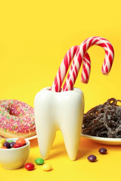 Concept of food bad for teeth on yellow background