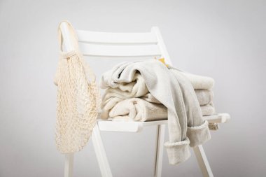 Wooden chair with autumn clothes, leaf and string bag
