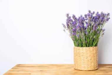 Wicker pot with lavender on wooden background
