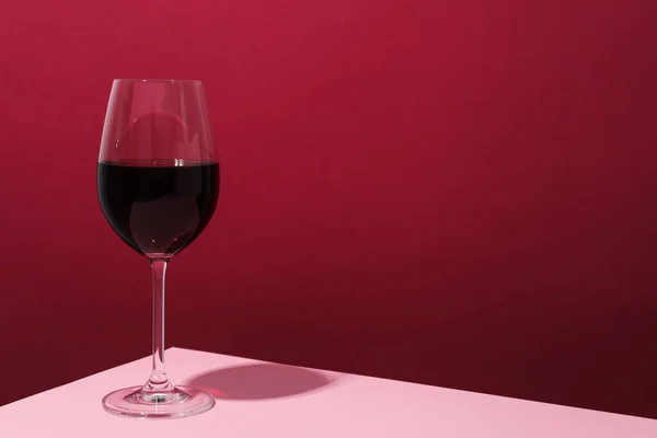 Copo Vinho Mesa Rosa Contra Fundo Carmesim Espaço Para Texto — Fotografia de Stock