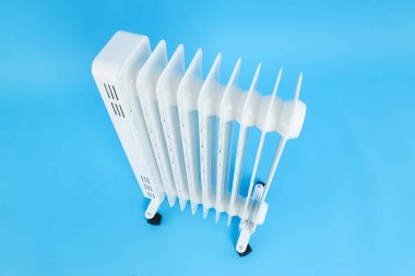 Modern white electric heater on blue background