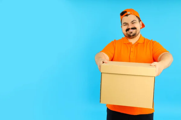 Concept of people, fat delivery man with box on blue background
