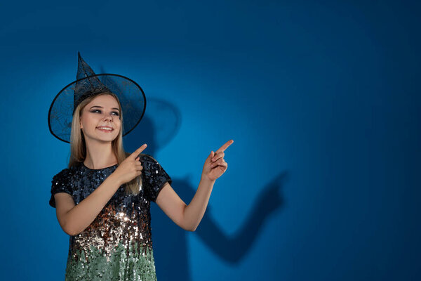 Concept of Halloween, young woman on blue background