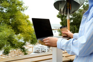 Dışarıda dizüstü bilgisayarda çalışan genç bir kadın, serbest yazar kavramı.