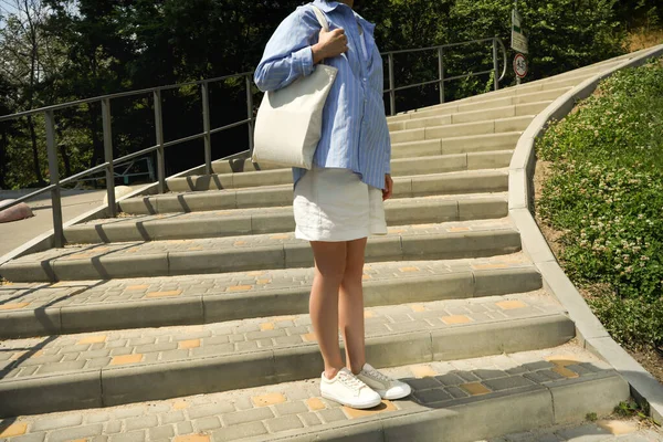 Young woman with cotton bag outdoor in summer day