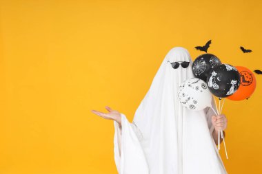 Cadılar Bayramı kavramı, sarı arka planda balonları olan Hayalet.