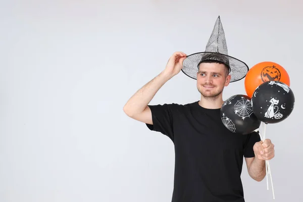 Concept of Halloween, Guy with Halloween balloons on light background