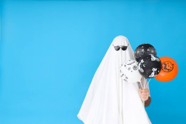 Cadılar Bayramı kavramı, mavi arka planda güneş gözlüklü hayalet.