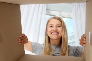 Teslimat kavramı, sürpriz, hediye, genç bir kadın bir karton kutu açtı.