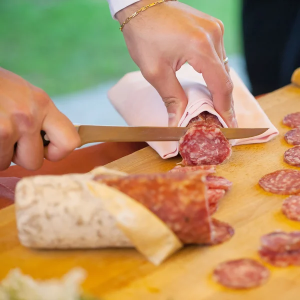 Camarero corta a rebanadas el salami —  Fotos de Stock