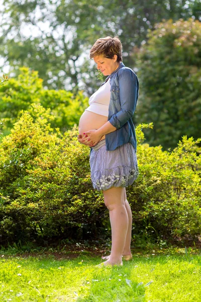 Беременная женщина на траве — стоковое фото