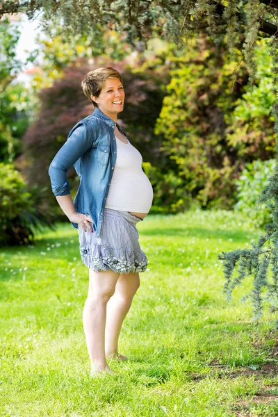 Беременная женщина на траве — стоковое фото