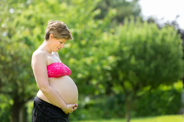 Femme enceinte sur l'herbe — Photo