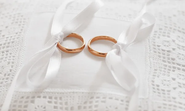 Zlaté snubní prsteny na jehelníček — Stock fotografie