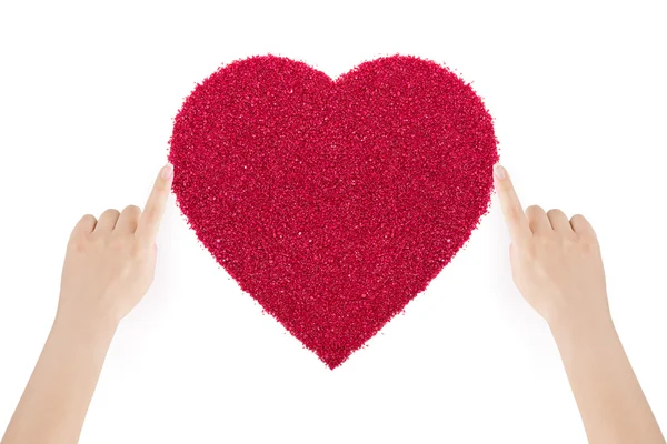 Mãos de mulher fazendo o coração de areia vermelha por dedos indicadores . — Fotografia de Stock