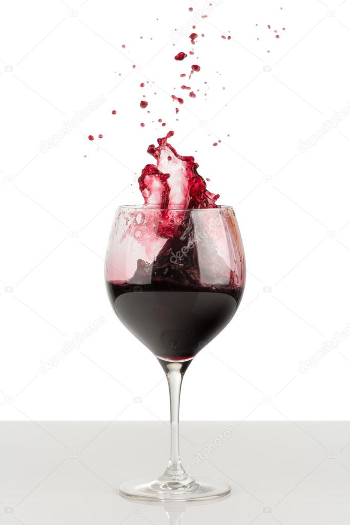 Splash of red wine in a wineglass.
