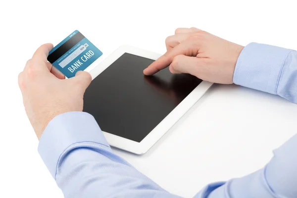 A mão do homem segurando um cartão de crédito sobre um computador tablet e o — Fotografia de Stock